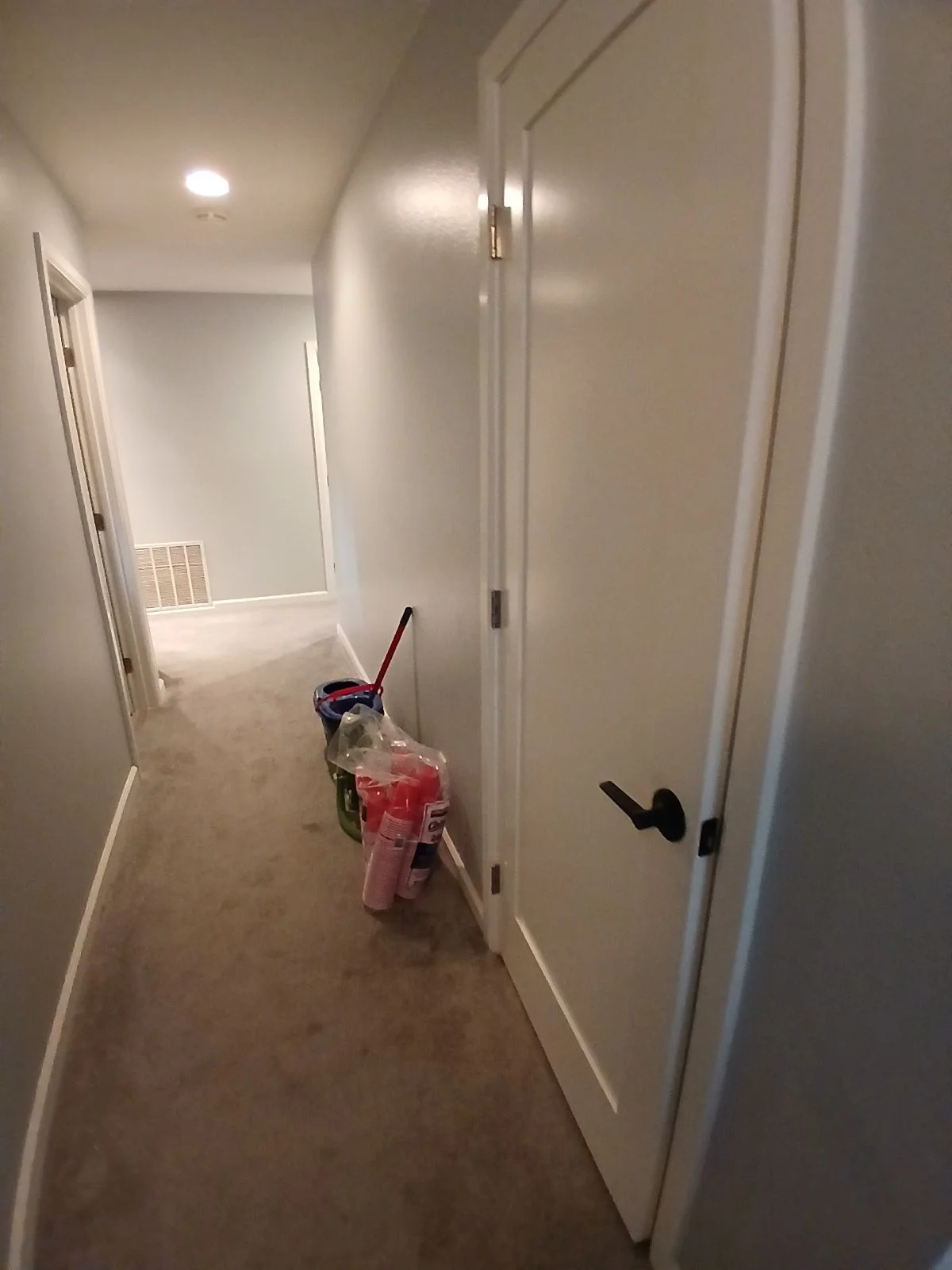 Hallway with finished drywall, interior doors, and recessed lighting