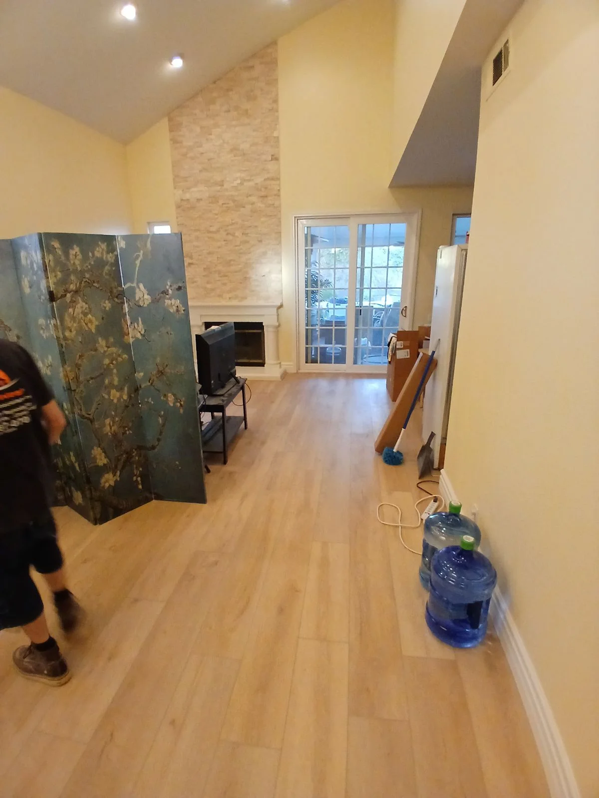 Commercial interior with laminate flooring, yellow walls, stacked stone accent wall, and recessed lighting