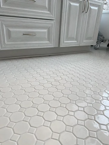 Light gray hexagonal ceramic tile flooring with grout lines in kitchen space