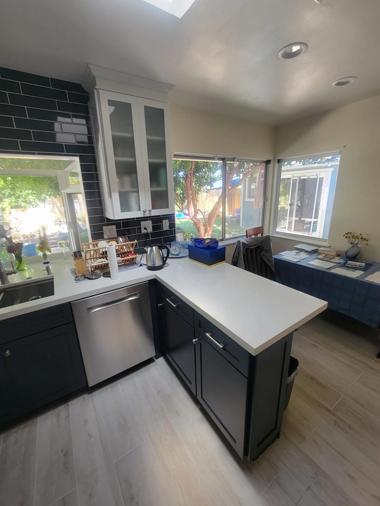 Kitchen with black subway tile backsplash, white quartz counters, island, and stainless steel appliances