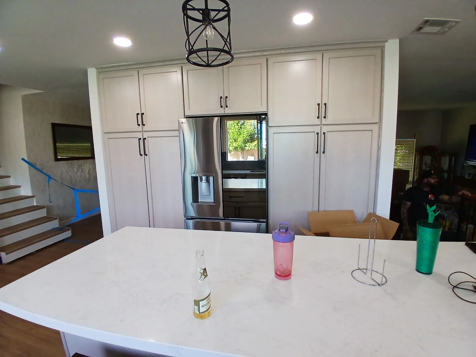 White shaker cabinetry, stainless steel appliances, quartz island countertop, recessed lighting in renovated kitchen