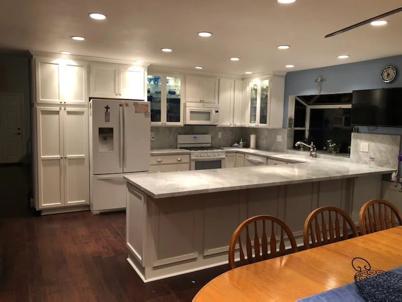 White kitchen cabinetry, quartz countertops, center island, stainless steel appliances, recessed lighting