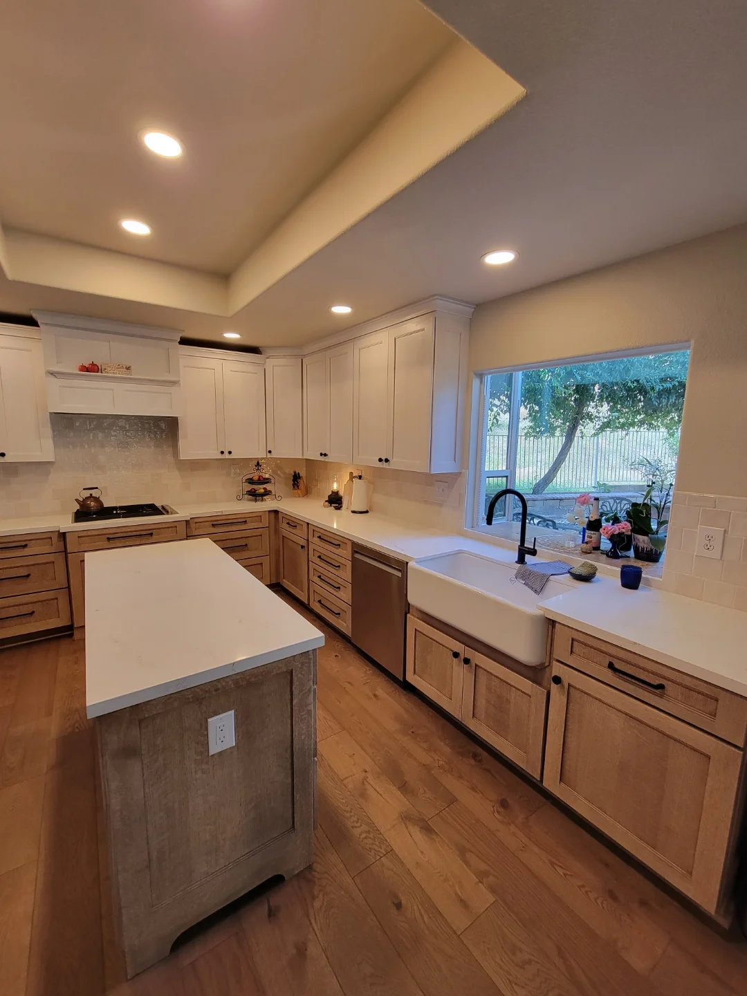 Kitchen with white and wood cabinetry, quartz counters, island, recessed lighting, and hardwood floors