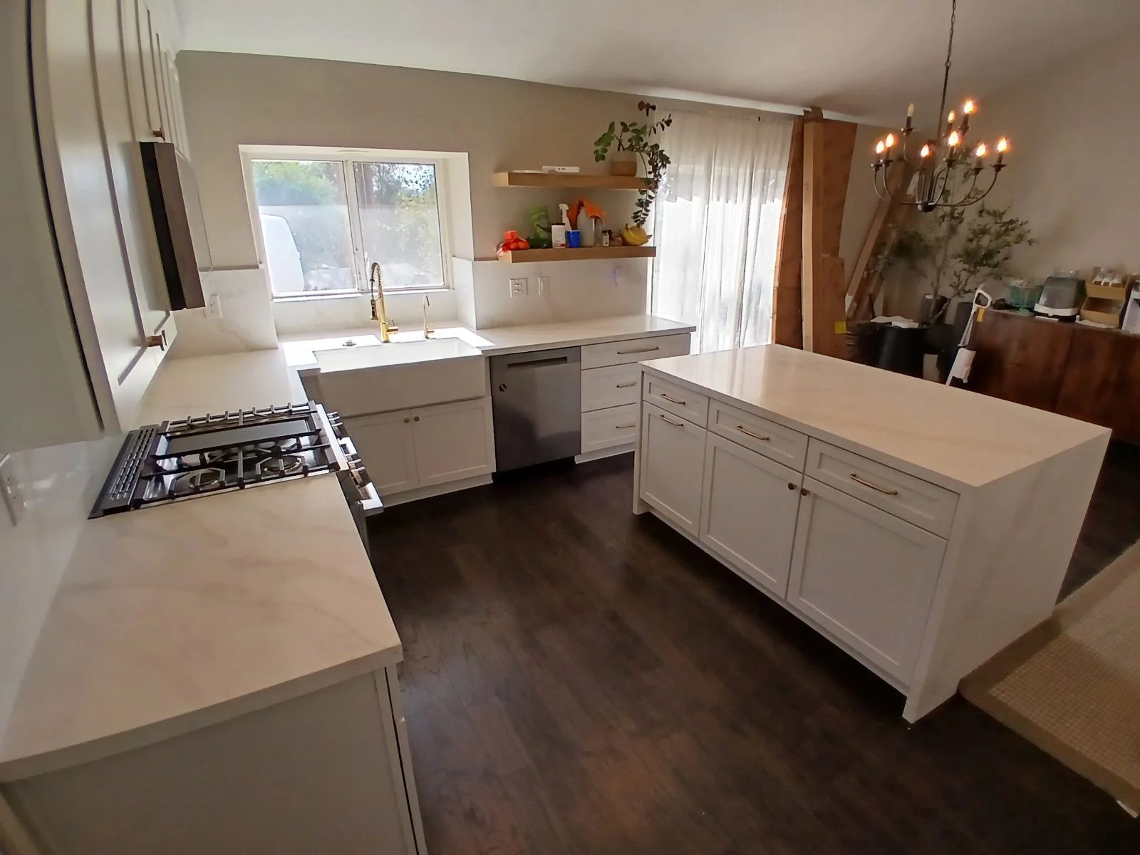 White kitchen cabinetry, quartz countertops, gas cooktop, island, hardwood flooring