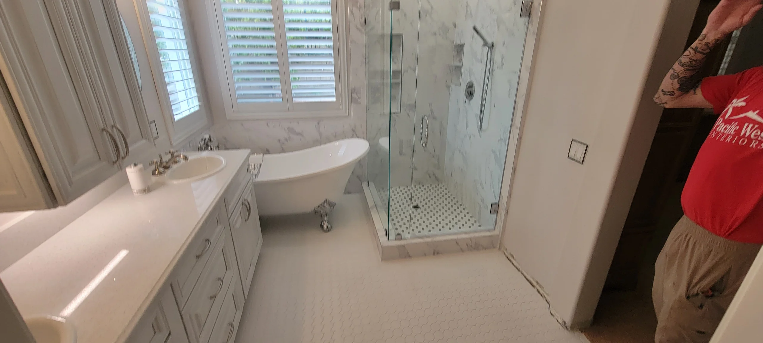Master bathroom with freestanding tub, dual vanity, marble tile shower, and glass enclosure