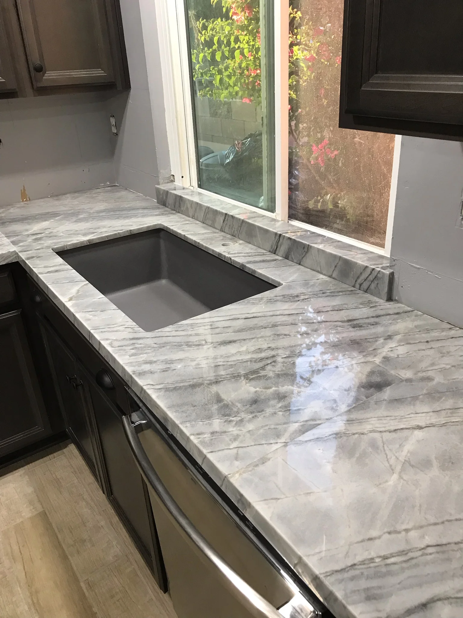 Marble kitchen countertop with gray veining and black undermount sink installation