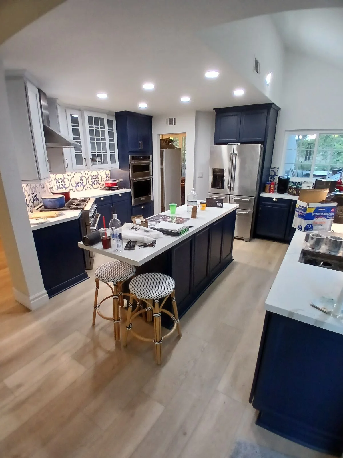 Navy cabinets, white quartz countertops, stainless steel appliances, center island with seating, recessed lighting