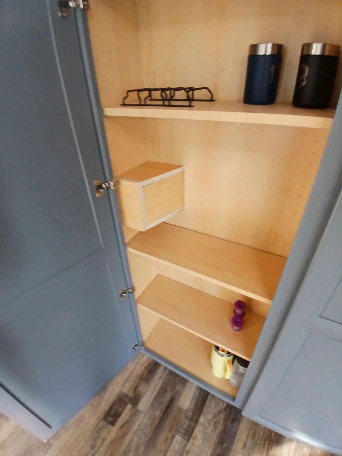 Birch plywood shelving system with white trim and drawer in closet interior
