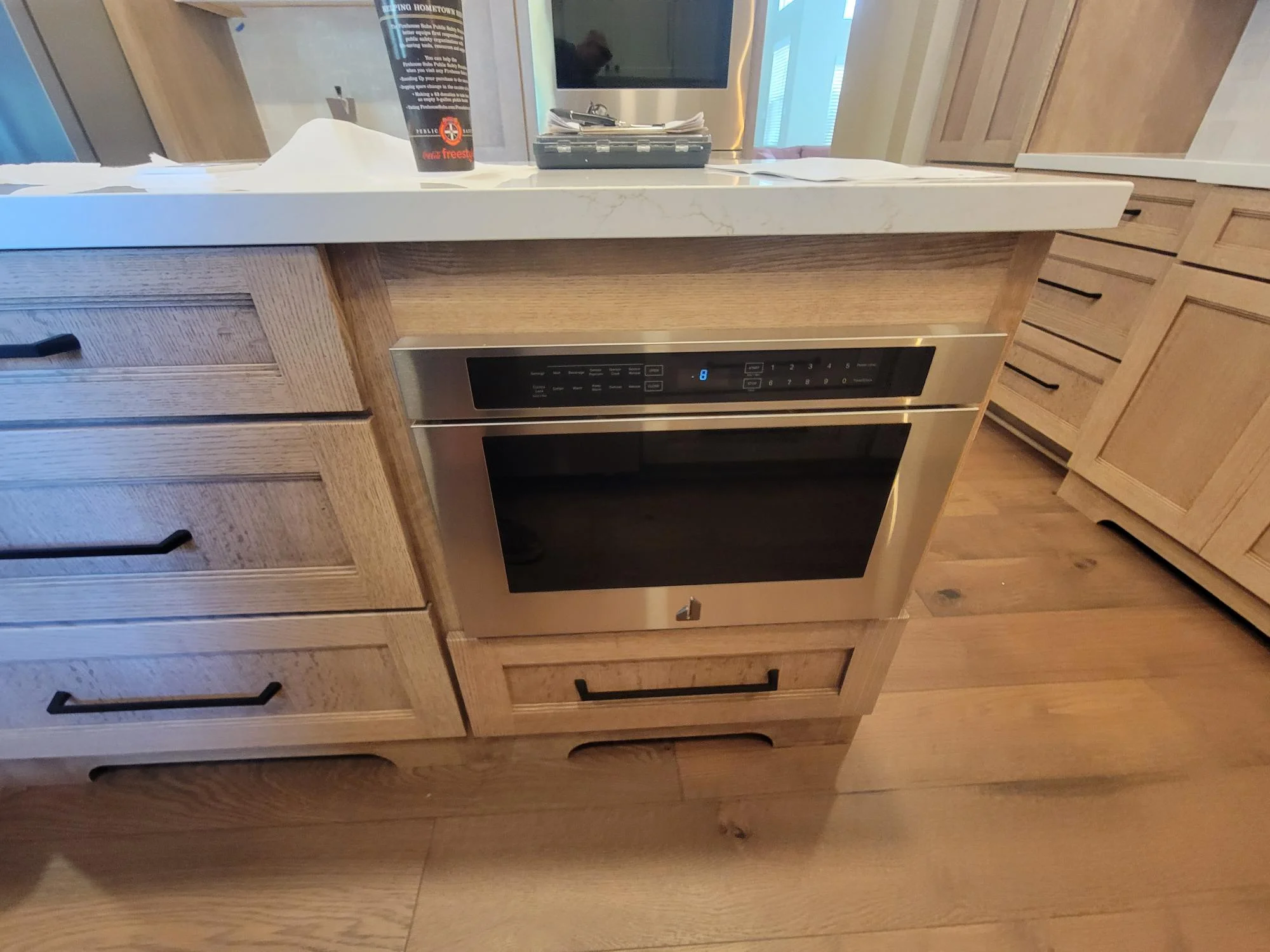 Custom wood kitchen cabinetry with built-in stainless steel microwave and quartz countertop