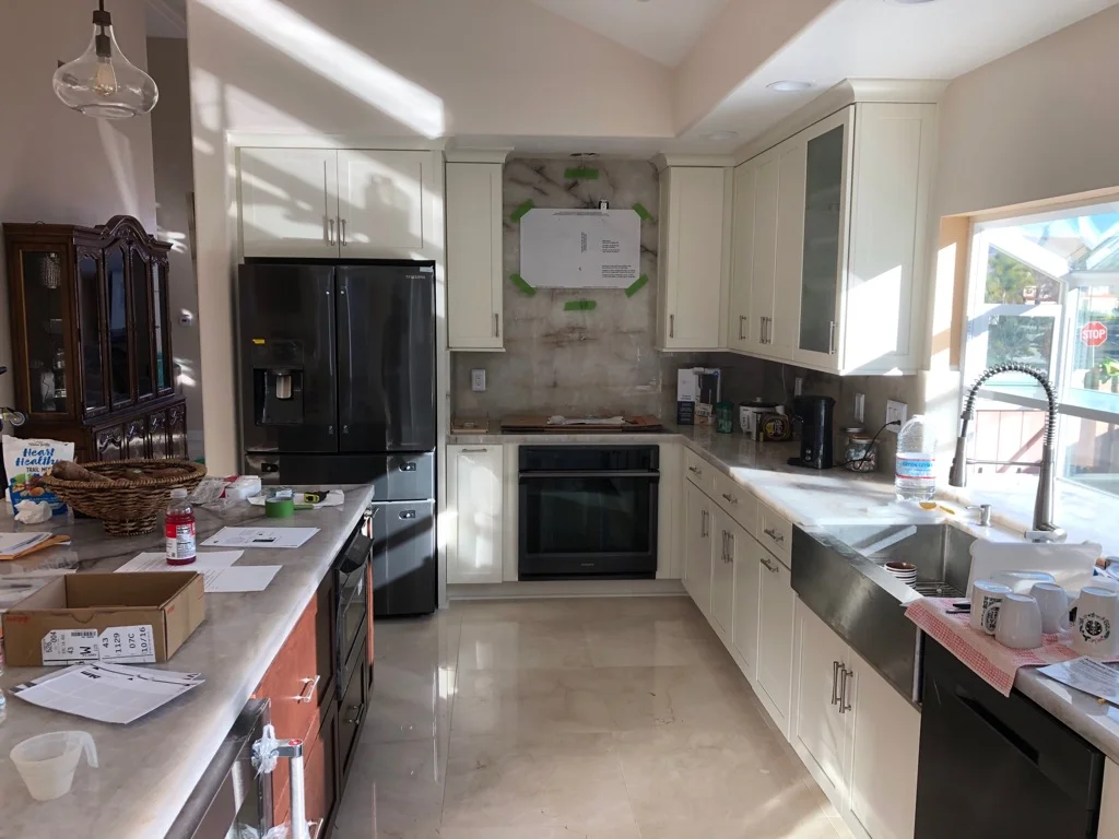 Kitchen with cream cabinets, black stainless appliances, concrete floors, and pendant lighting