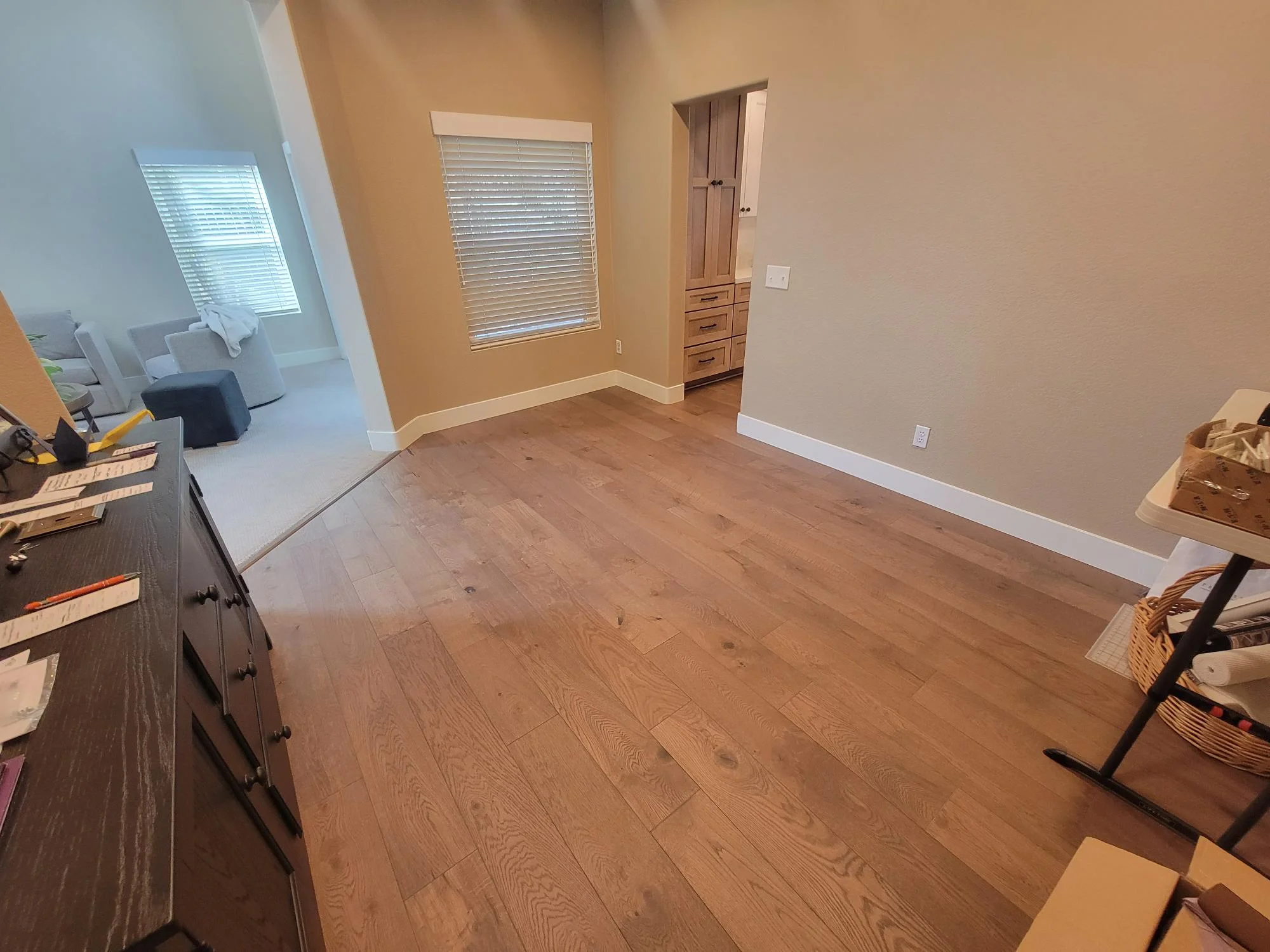 Hardwood flooring installation with warm oak tones, neutral wall paint, and custom built-in cabinetry