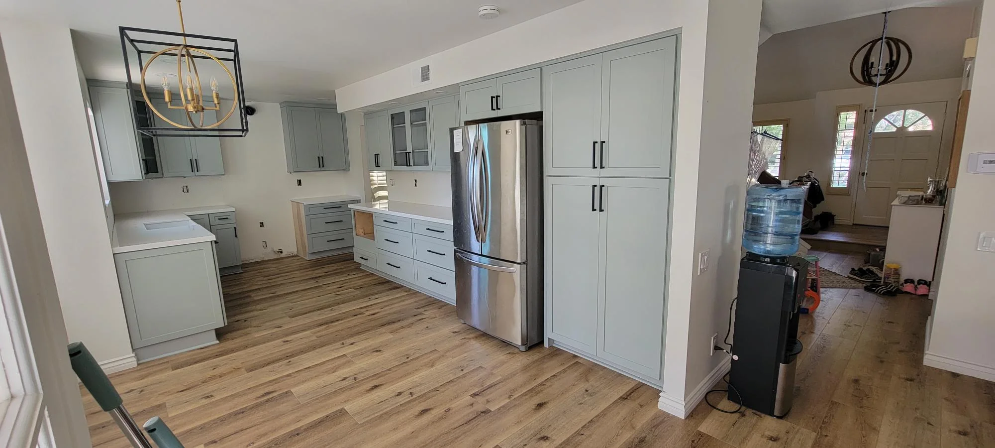 Light gray kitchen cabinets with stainless steel appliances and wood-look flooring