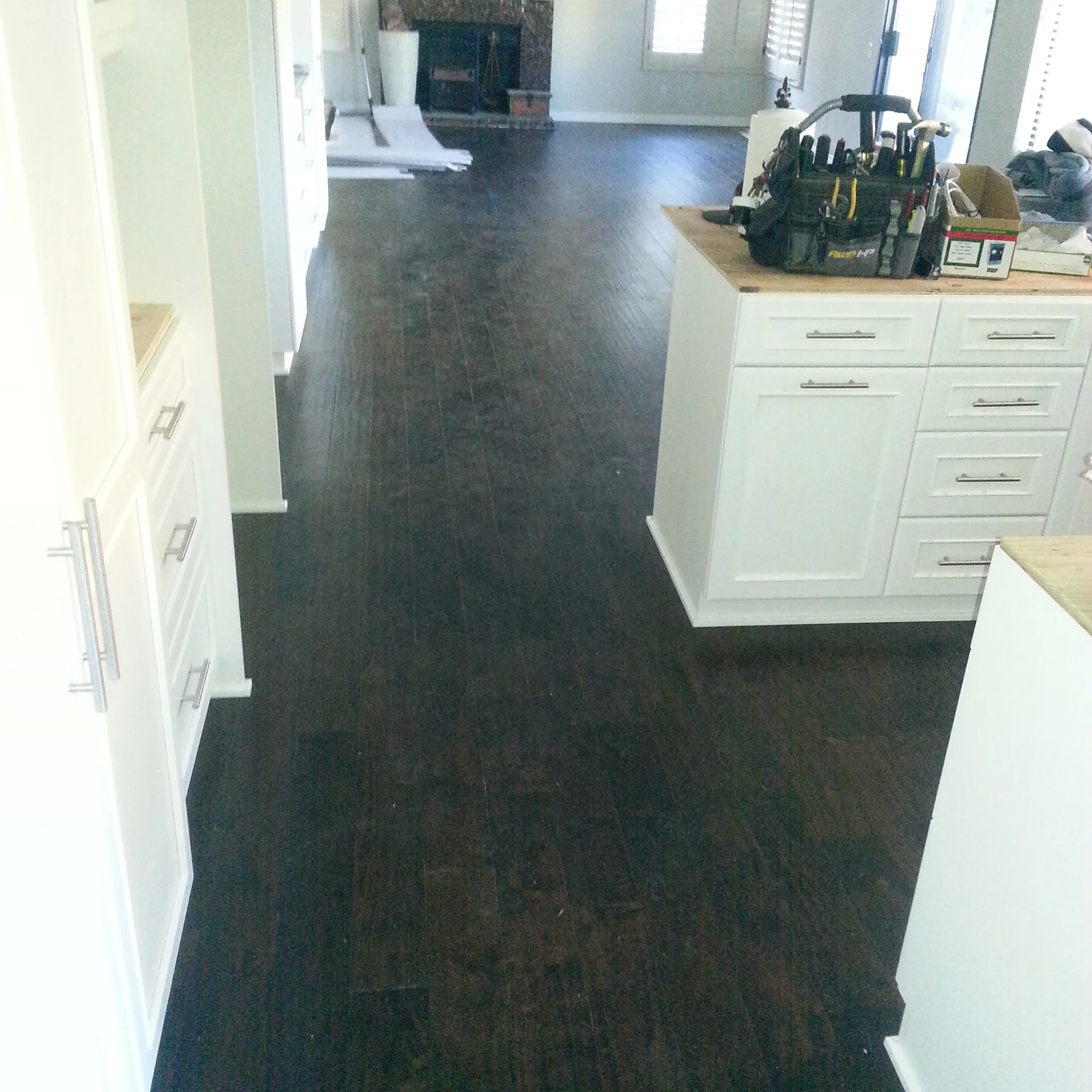 Dark wood plank flooring in kitchen with white cabinets and wood countertops