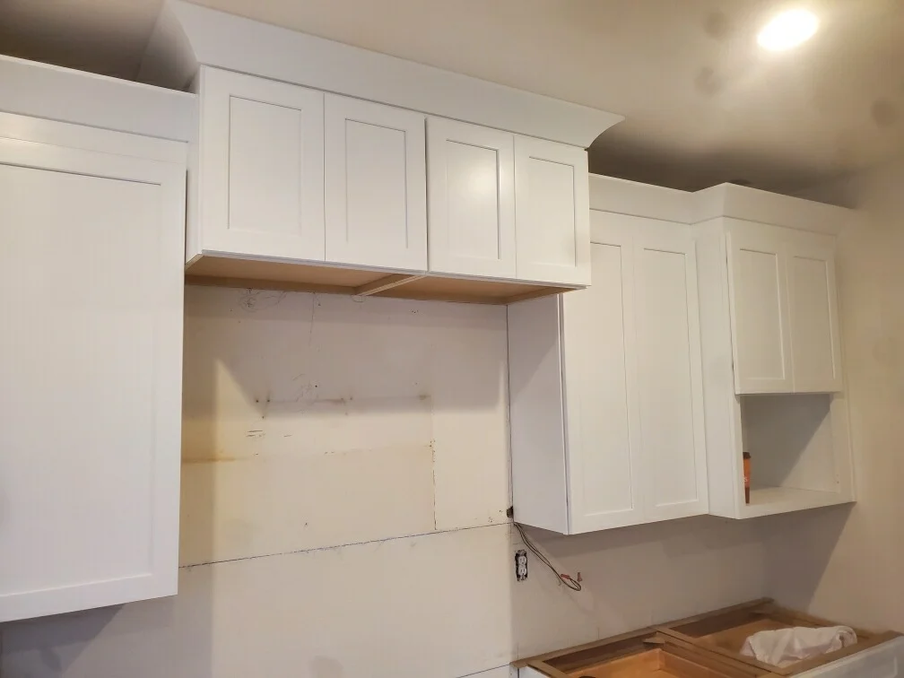 White shaker cabinetry with open shelving niche and recessed panel doors installed in drywall opening