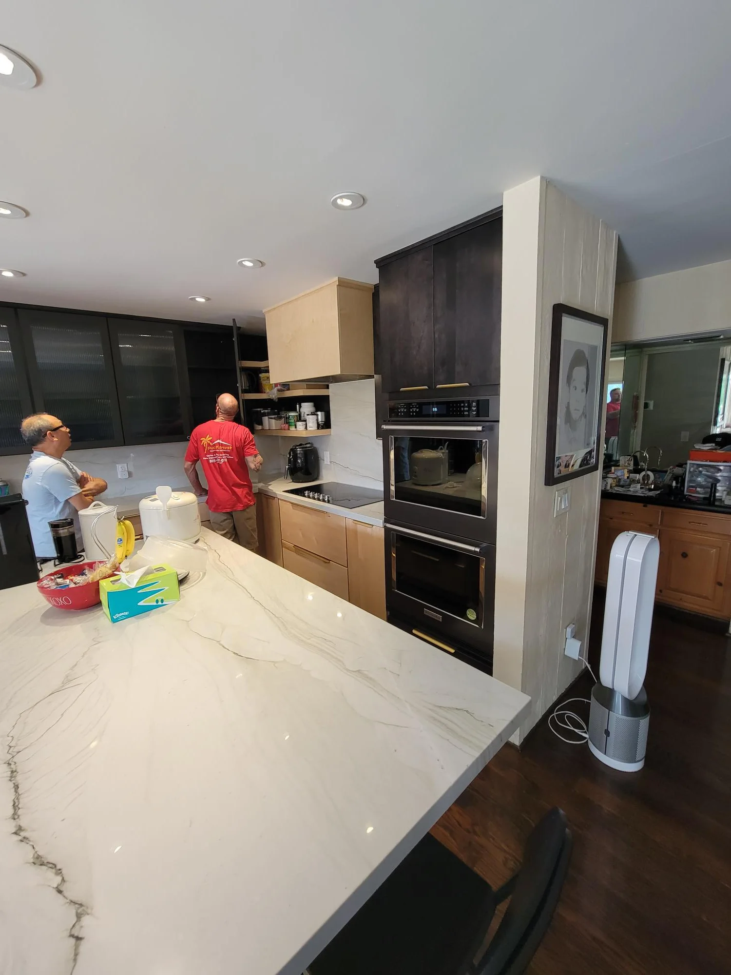 Kitchen with two-tone cabinets, quartz countertops, dual ovens, and recessed lighting